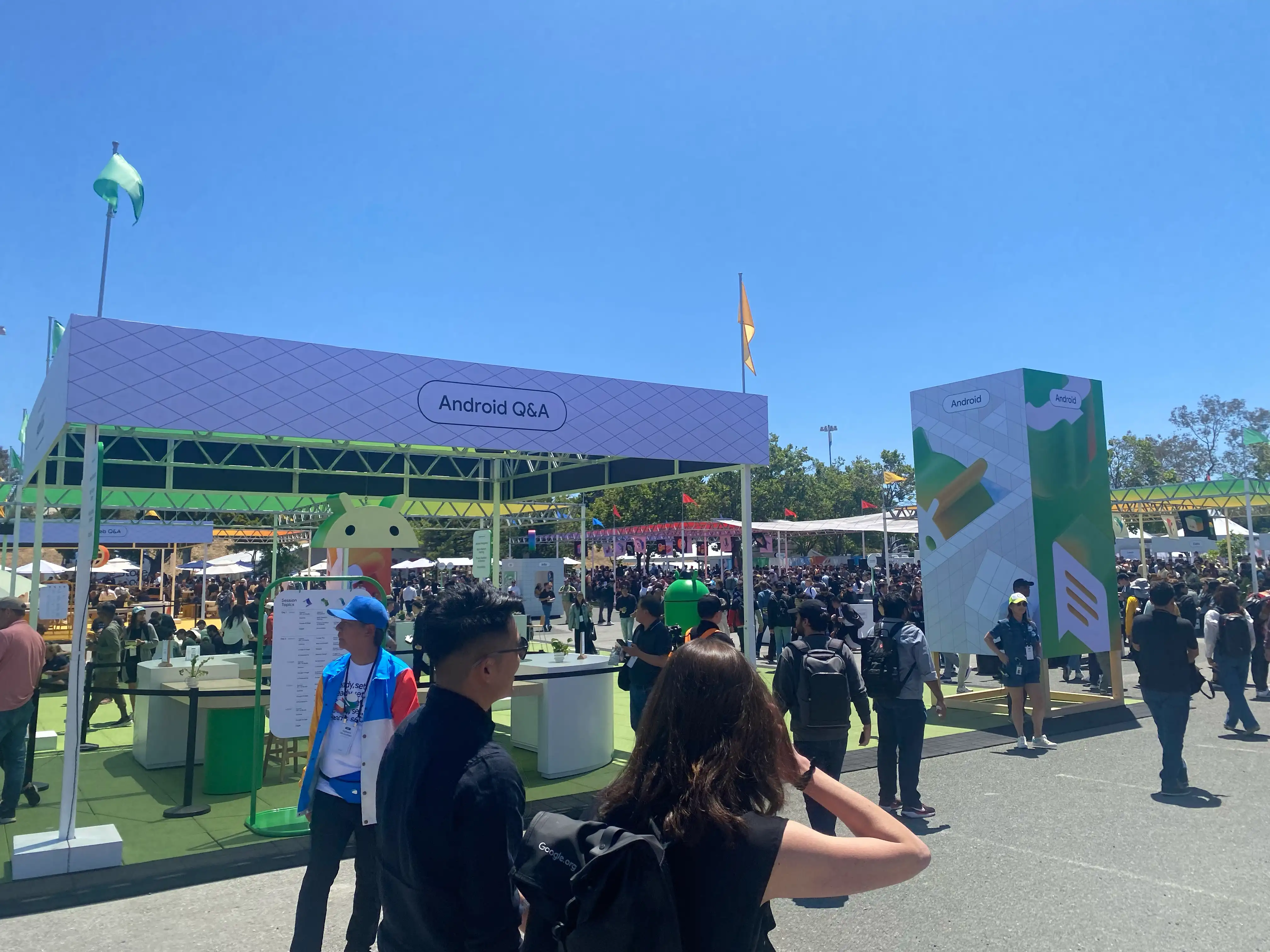Many people in the venue with a booth labeled "Android Q&A" and a standing sign that says "Android."