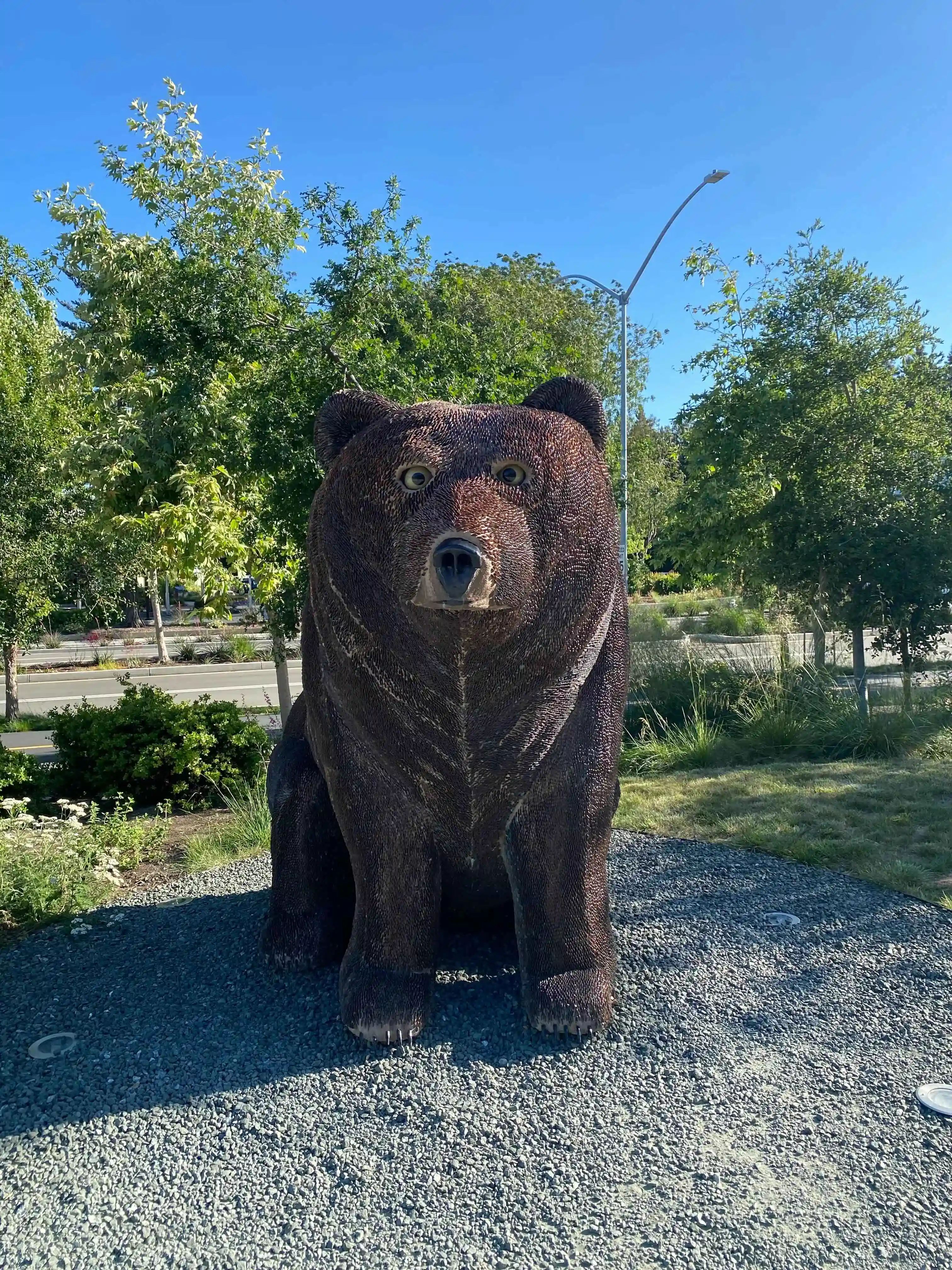 An art object of a cute-faced bear sitting in a dog-like pose, looking at the viewer