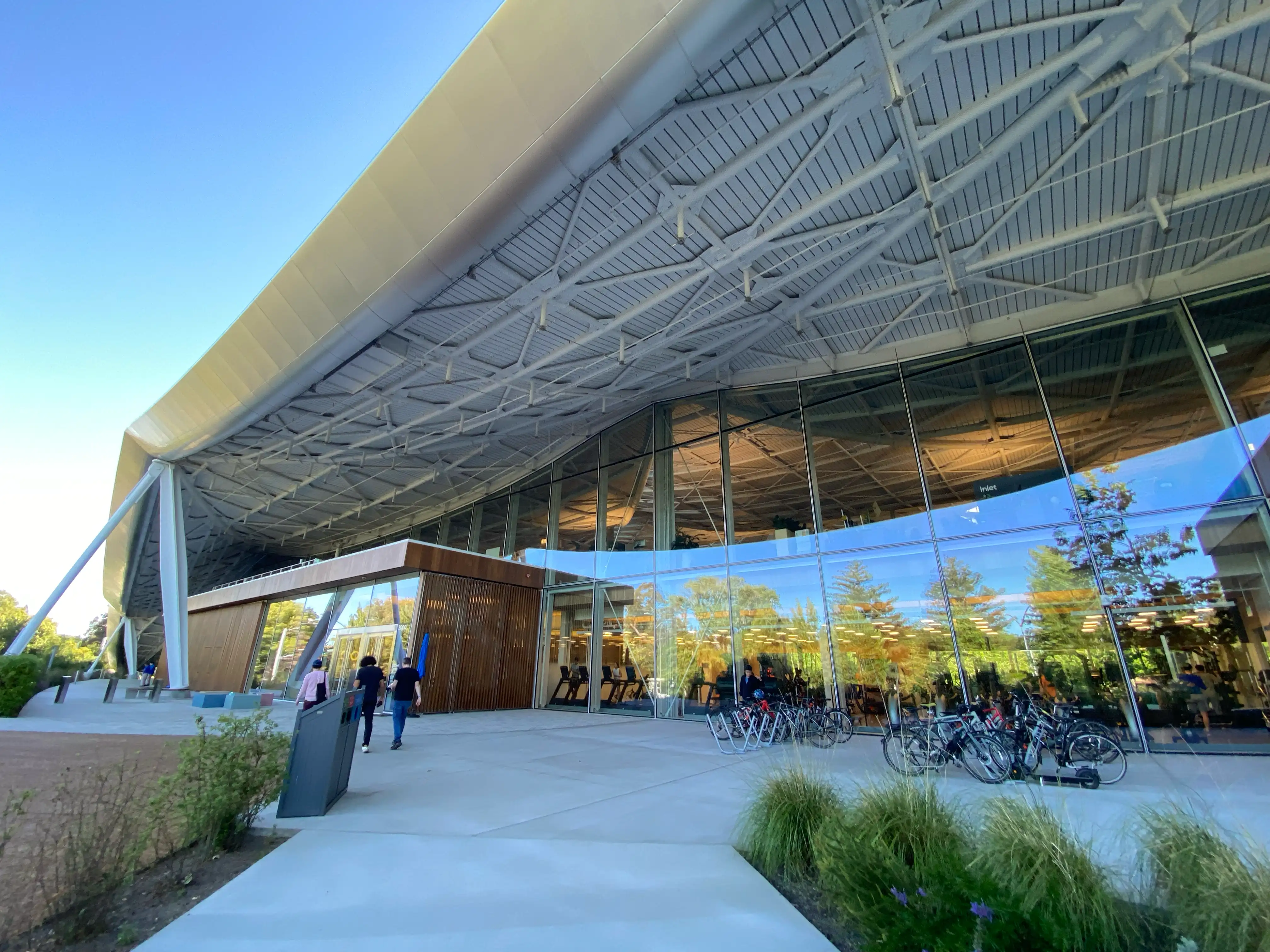 A photo of a glass-walled building with a large roof