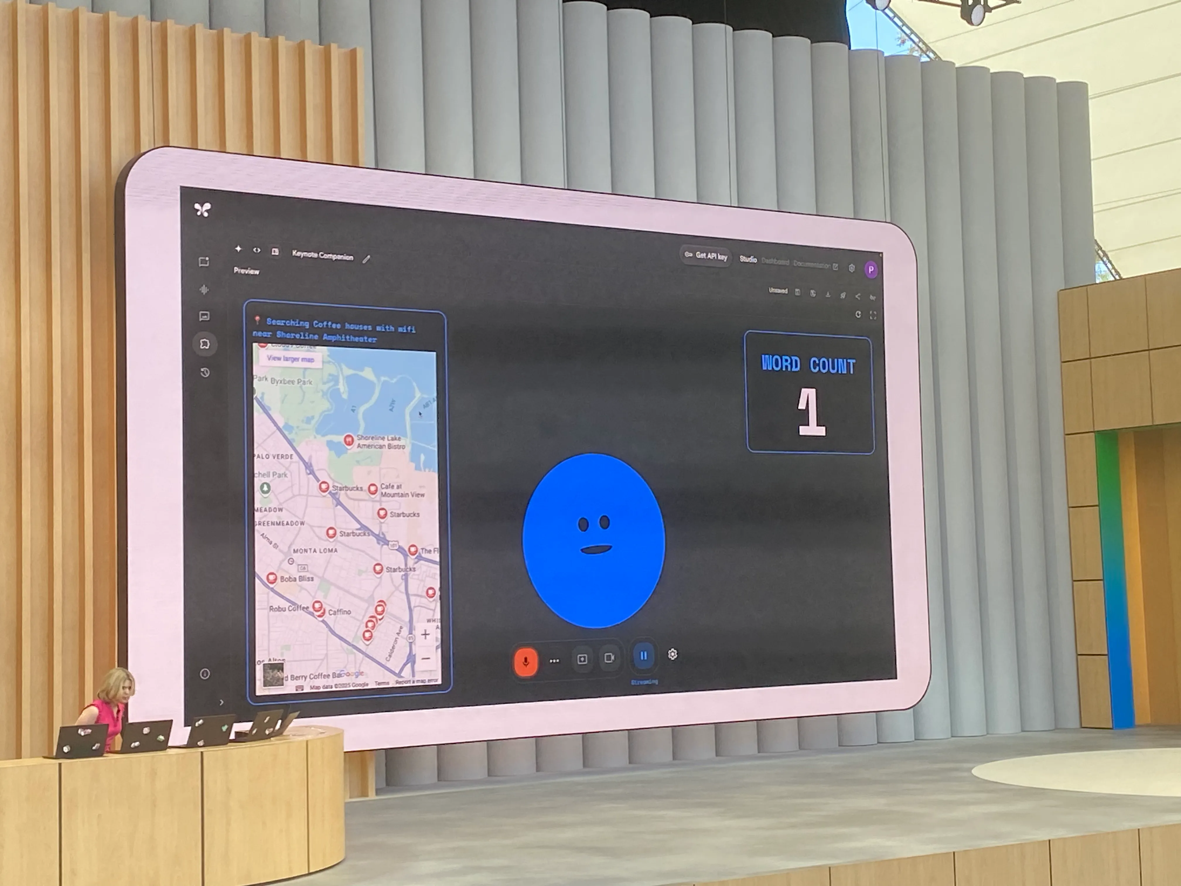 A photo of a session in progress, showing a large screen and a presenter.