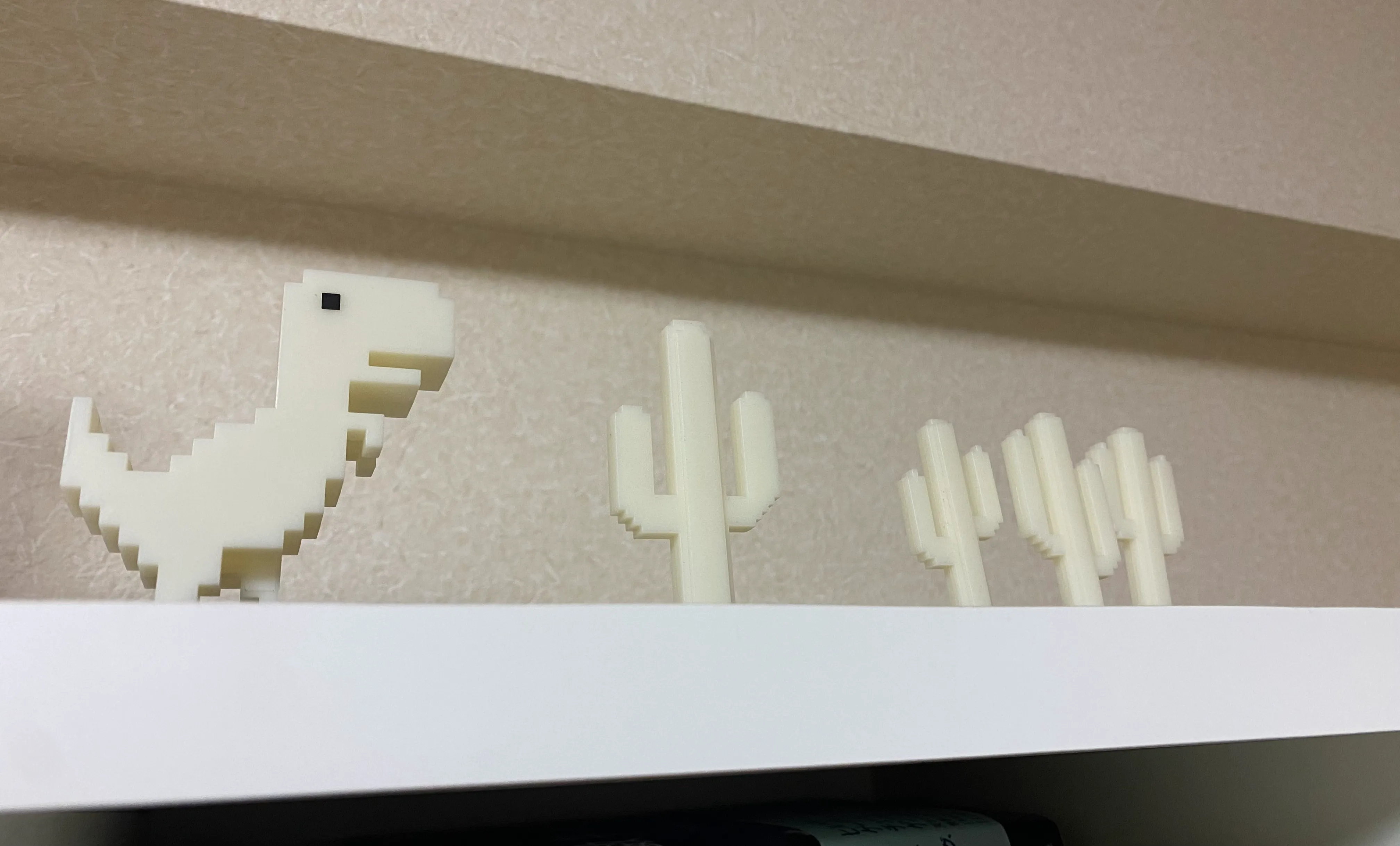 A bookshelf displays Dino figurines arranged in a row, accompanied by trees that Dino jumps over.