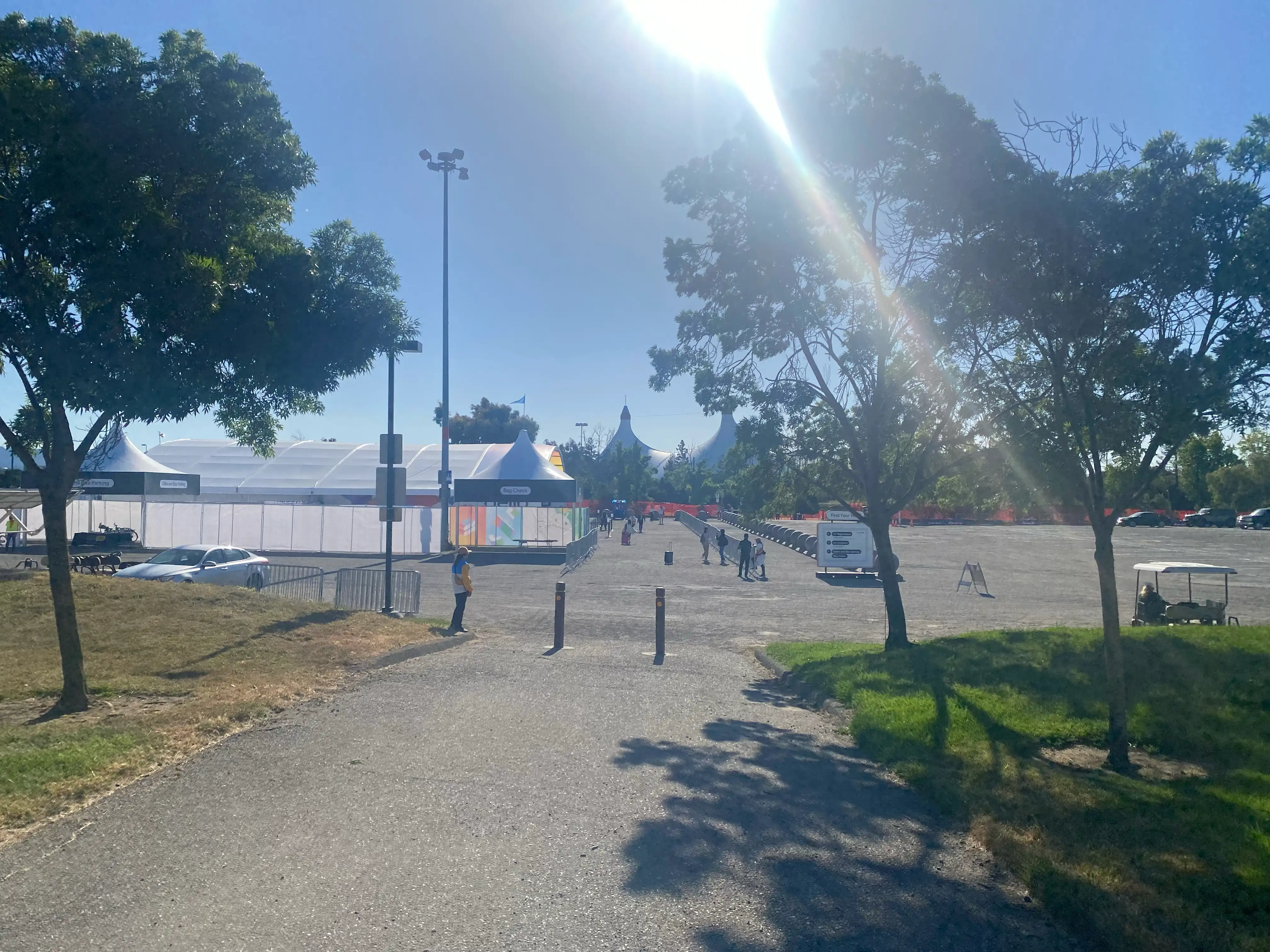 A slightly blurry photo of what appears to be the venue, with the sun and its strong light reflecting. A large tent structure is visible in the foreground