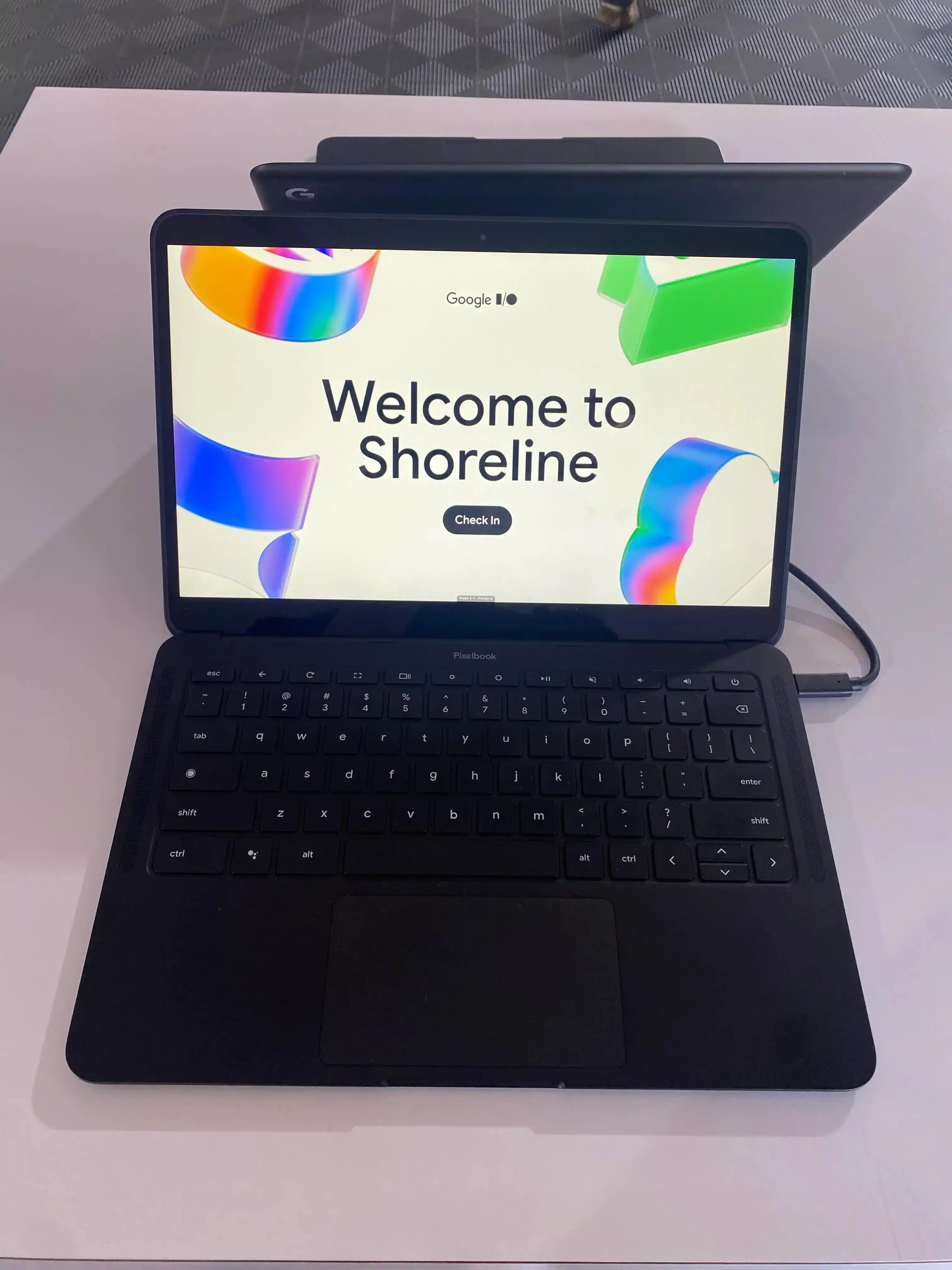 A Pixelbook displaying "Welcome to Shoreline" and a small I/O logo