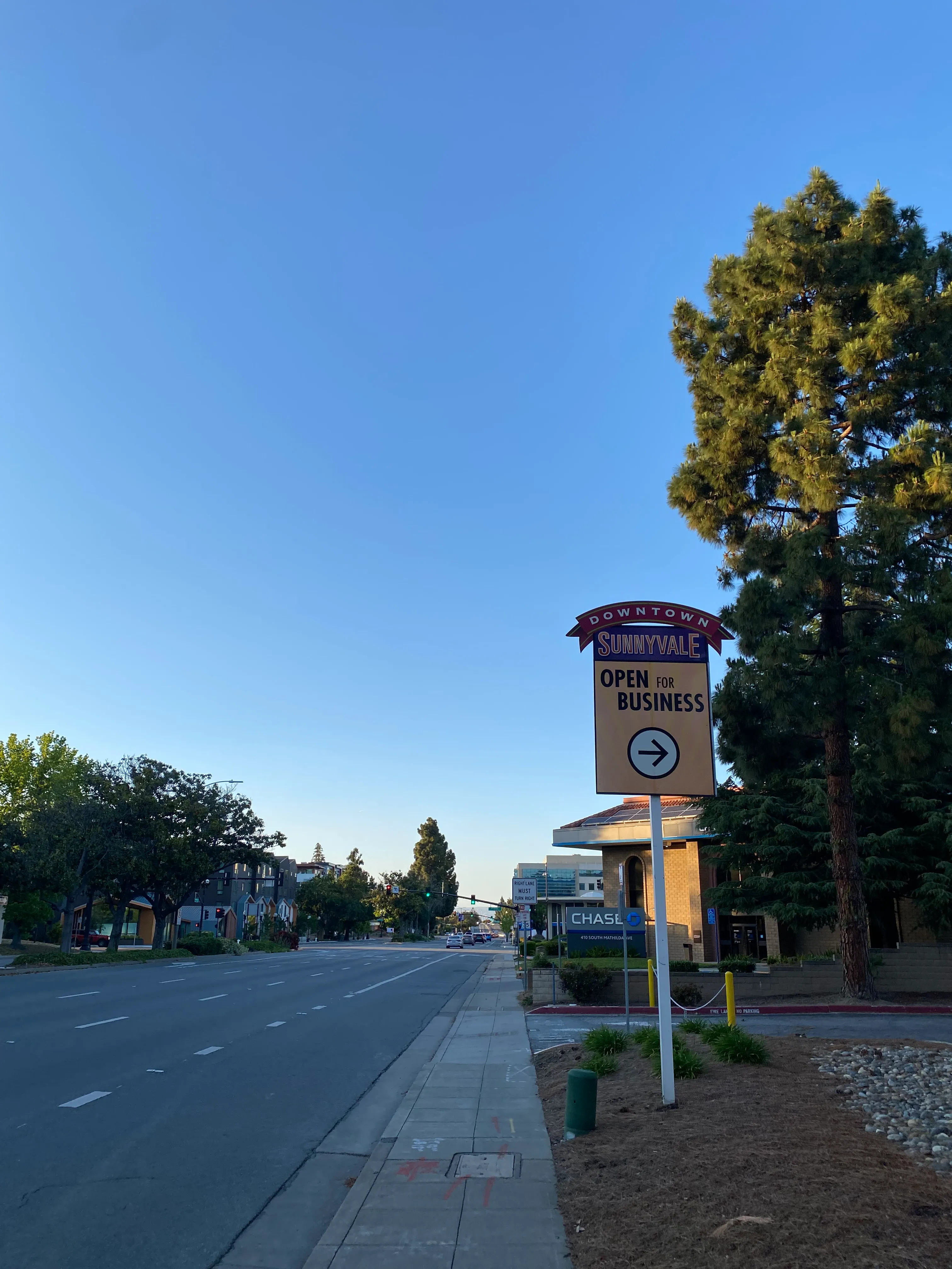 Photo of an empty street. There's a sign that reads 'Downtown Sunnyvale Open For Business'.