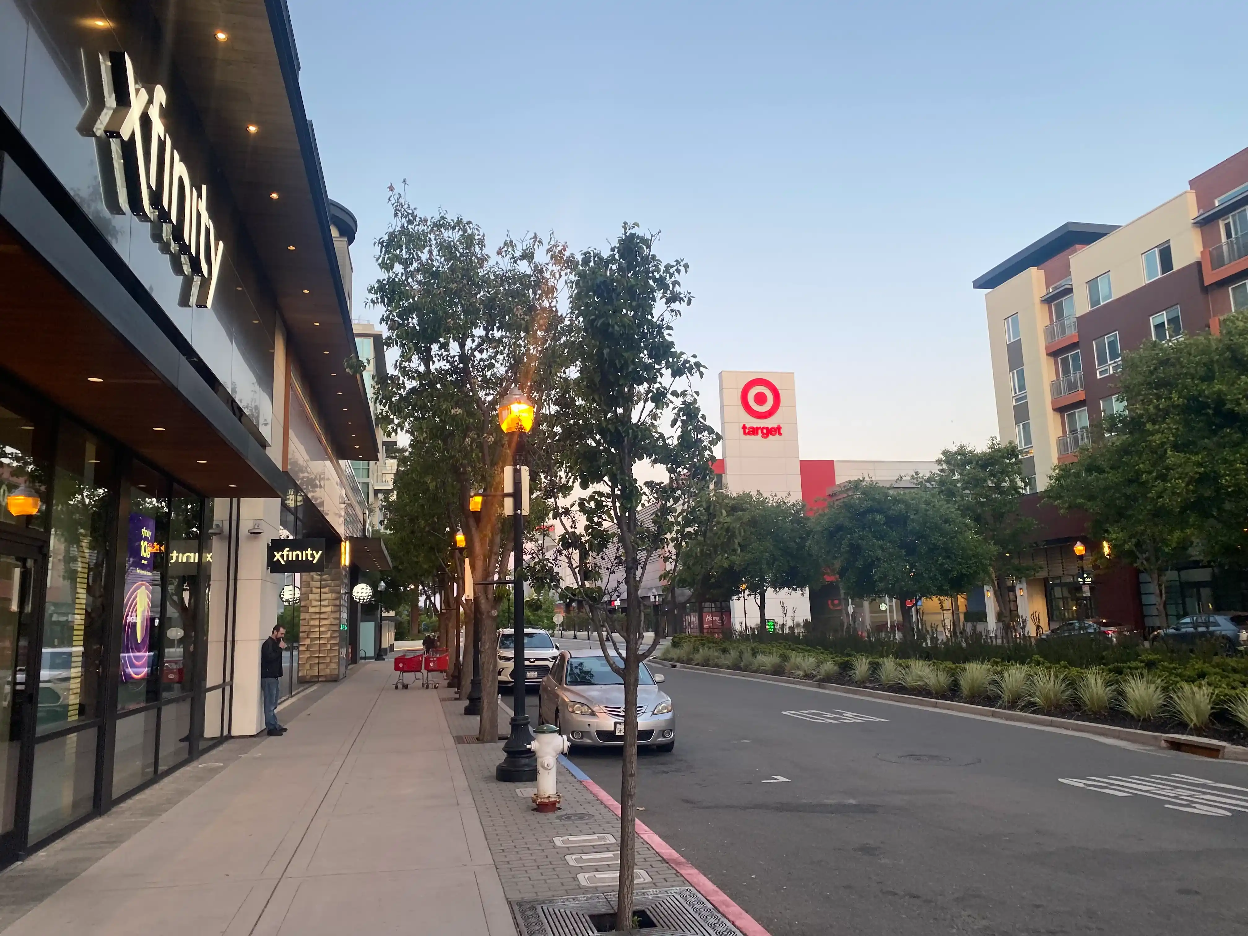 Photo of a street with bars and a Target store visible. Only one person is present.